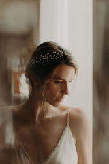 femme de profil avec un chignon bas et sa couronne de bourgeons en porcelaine froide nacrée et mate