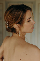 femme de profil qui porte une boucle d'oreilles en porcelaine nacrée