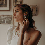 la femme porte une paire de boucles d'oreilles de mariage en nacre cérémonie