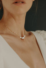 gros plan sur une femme qui porte un collier avec 3 nacres