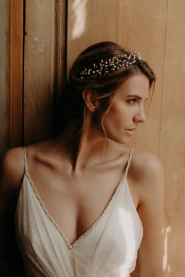 femme de profil avec un chignon bas et sa couronne de bourgeons en porcelaine froide nacrée et mate